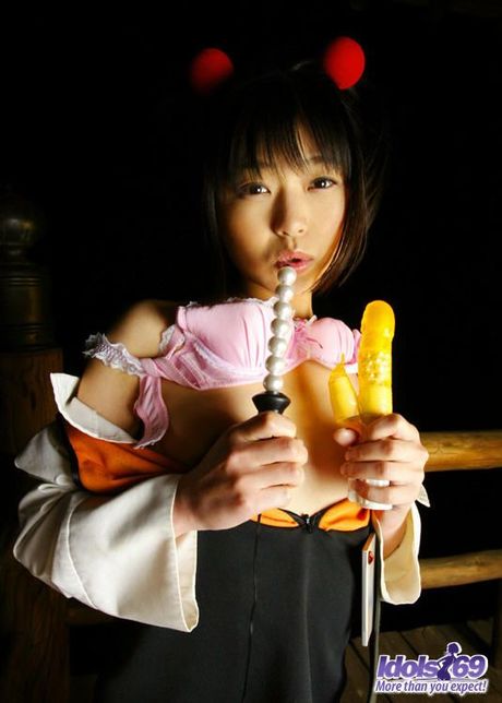 Asian slut in pigtails and uniform shows her hairy pussy and her favorite toys