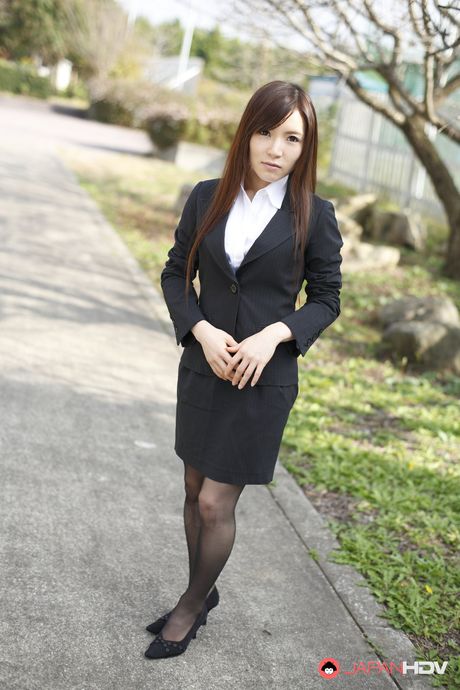 Naughty Hitomi Tsukishiro in office outfit poses so sexy outdoors.