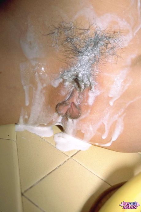 Amateur Asian girl with tiny tits toying her pussy in the kitchen